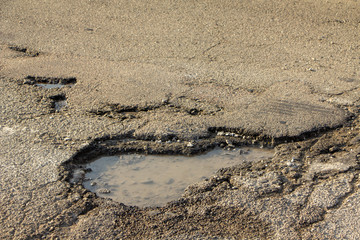 Fototapeta na wymiar there are many potholes on the roadway close up