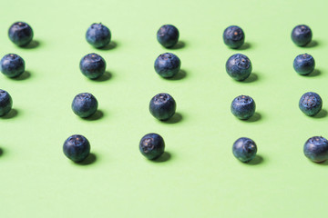Pattern of fresh blueberries in on pastel green background. Healthy breakfast concept