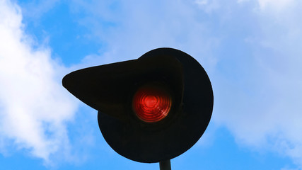 The traffic light flashes red. Against the background of blue sky with clouds. Traffic lights on...