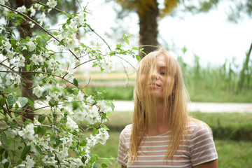 Beautiful blond girl posing for photo at the national park in stripes dress