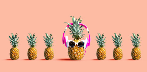 One out unique pineapple wearing headphones on a solid color background