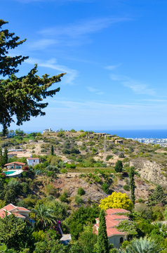 Vertical picture of amazing coastal landscape in Kyrenia region, Northern Cyprus. Rural houses surrounded by green trees are overlooking the Mediterranean. Popular vacation spot
