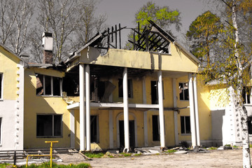 Burnt down after fire large country house with a collapsed damaged roof against a grey sky. burnt down large country house with a collapsed damaged roof against a grey sky