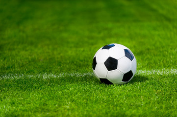 Fototapeta na wymiar Black and white soccer ball in the field
