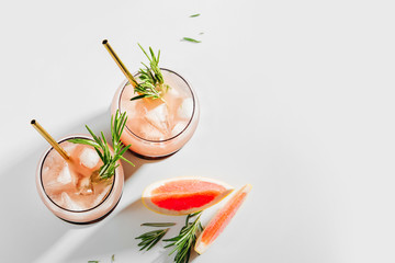Two glass with Grapefruit and Rosemary cocktail. Summer drinks with fresh citrus and ice.