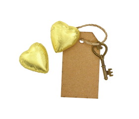 key, chocolate heart and a piece of recycled paperboard with space for text . love message. key ties with rope