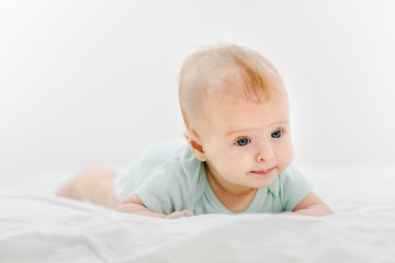 Portrait of cute newborn baby lying on belly at home