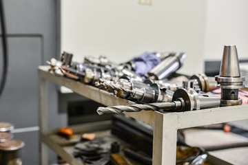 Mandrels and accessories for the CNC milling machine are located on the machine near the industrial equipment. Drills, cutters, cutters for metal processing.