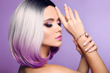 Beautiful lady presents amethyst ring and bracelet jewelry set. Woman portrait with ombre bob short hairstyle and manicured nails. Beauty makeup. Gorgeous model isolated on purple background.