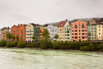 Colorful houses in Innsbruck with Inn river in the background. Beautiful view of the historic city center of Innsbruck.