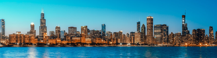 Fototapeta na wymiar Beautiful cityscape panorama view of buildings in Chicago downtown district at twilight blue hour, banner size. America tourism, travel destination, tourist attraction, or American city life concept