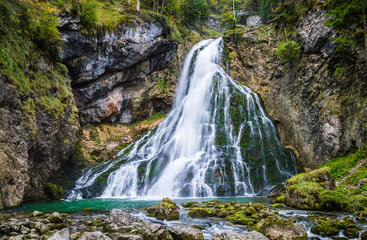 Gollinger Waterfall in Golling an der Salzach near Salzburg, Austria. Stunning view of cascade waterfall over mossy rocks in the Alps with long exposure