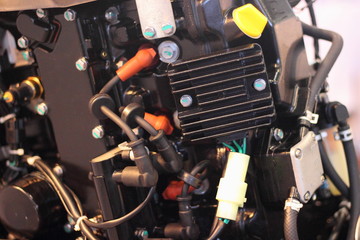 Fototapeta na wymiar Boat outboard motor ignition system - CDI controller and high-voltage wires with caps