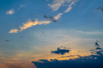 Blue sky with gold clouds - dramatic sunset, beautiful natural background. Setting sun illuminates the clouds.