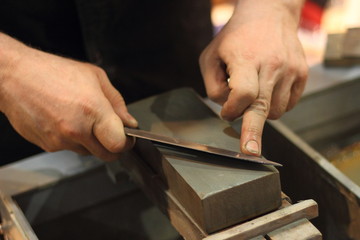 Manual sharpening blade of knife on a grinding stone