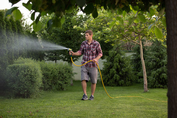 Man watering plants in garden