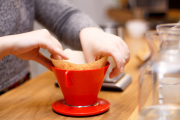 red filter coffee and a kettle and hands close-up coffee shop on a wooden table