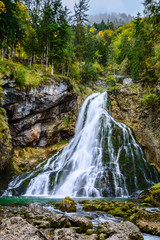 Fototapeta na wymiar Gollinger Waterfall in Golling an der Salzach near Salzburg, Austria. Stunning view of cascade waterfall over mossy rocks in the Alps with long exposure