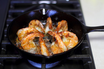 Shrimp Scampi cooking in a cast iron pan on the stove.