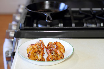 Plate of shrimp scampi next to the stove.