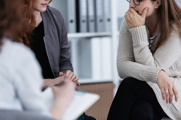 Sad girl with psychotherapist. Women's issues support group concept