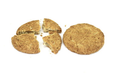 Broken biscuit with falling crumbs down. Round whole wheat biscuit, cookie with raisins isolated on white background. Biscuits with whole-wheat (wholemeal) flour isolated on white.