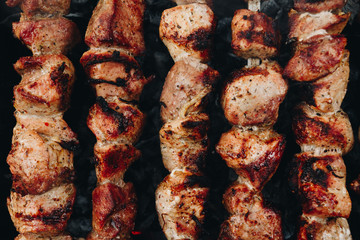 Closeup of some meat skewers being grilled in a barbecue