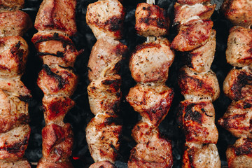 Closeup of some meat skewers being grilled in a barbecue