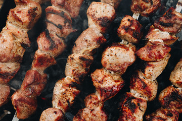 Closeup of some meat skewers being grilled in a barbecue
