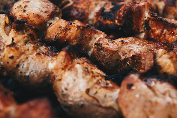 Closeup of some meat skewers being grilled in a barbecue