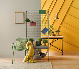 Green metal chair with yellow blanket, brown and yellow wall, home ornamnet.