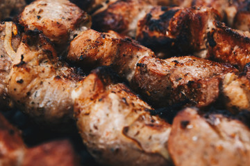 Closeup of some meat skewers being grilled in a barbecue