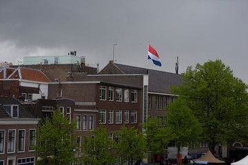 Fototapeta na wymiar Dutch flag waving on the top of the building during the King`s day