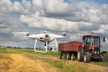 Fototapeta na wymiar Drone in front of tractor in field