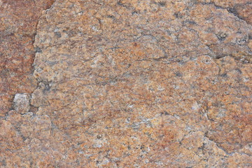 Texture of granite stone. Background of granite. Pattern of roughened surface. Texture of brown stone