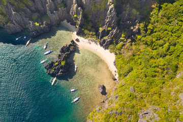 Beautiful lagoon surrounded by cliffs.Aerial drone view of swimmers inside a tiny hidden tropical lagoon surrounded by cliffs Philippines, Palawan,Busuanga,