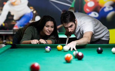 Young couple playing snooker