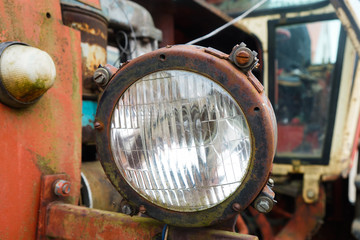 Headlight of an old tractor on a horse farm close up
