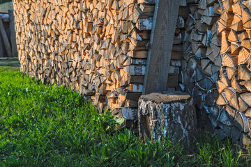 A woodpile of dry birch wood in the backyard of the house close-up. Pile firewood prepared for fireplace.