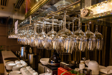 Wine glasses hang above the bar in a hotel.