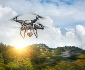 Dark drone in the air against the backdrop of a mountain landscape.