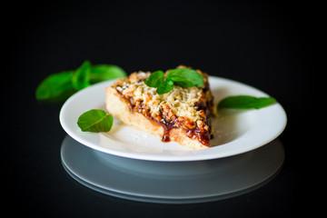 sweet cake with fruit jam in a plate on a black