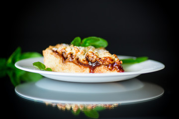 sweet cake with fruit jam in a plate on a black