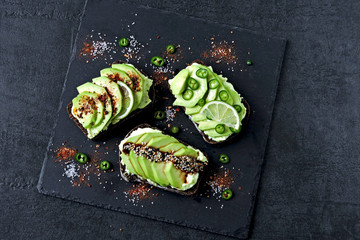 Avocado toasts on a stone board.