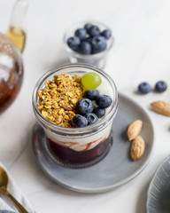 Close up granola with jam, cream and berries in jar