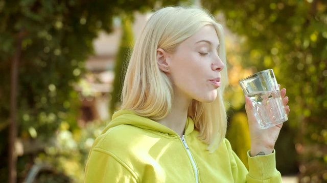 Face portrait of woman with glass water. Young woman drinking water. Clouse up portrait of blonde girl. Clean health water concet.