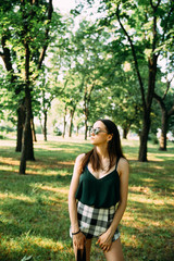 Beautiful young girl in a park in sunglasses