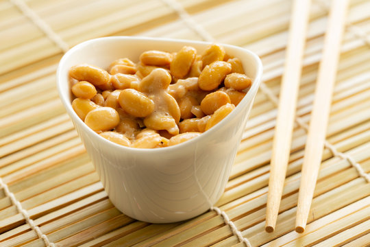 Eating healthy traditional japanese fermented soybeans called natto with chopsticks