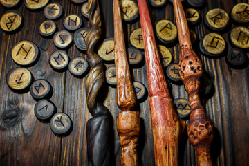Homemade magic wands and wooden runes on a dark wooden background - obrazy, fototapety, plakaty