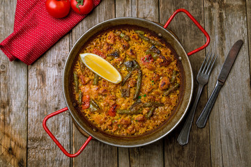 paella with chicken on wooden background